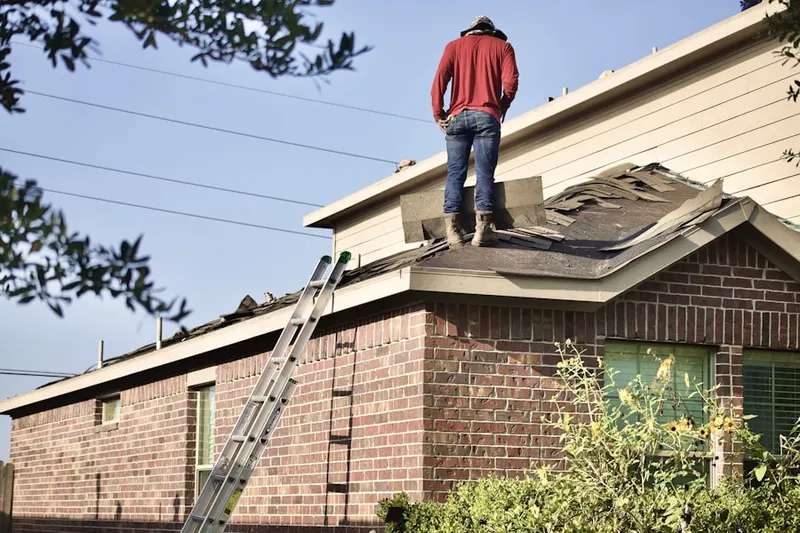 Professional roofer working on a residential roof in Woodmere